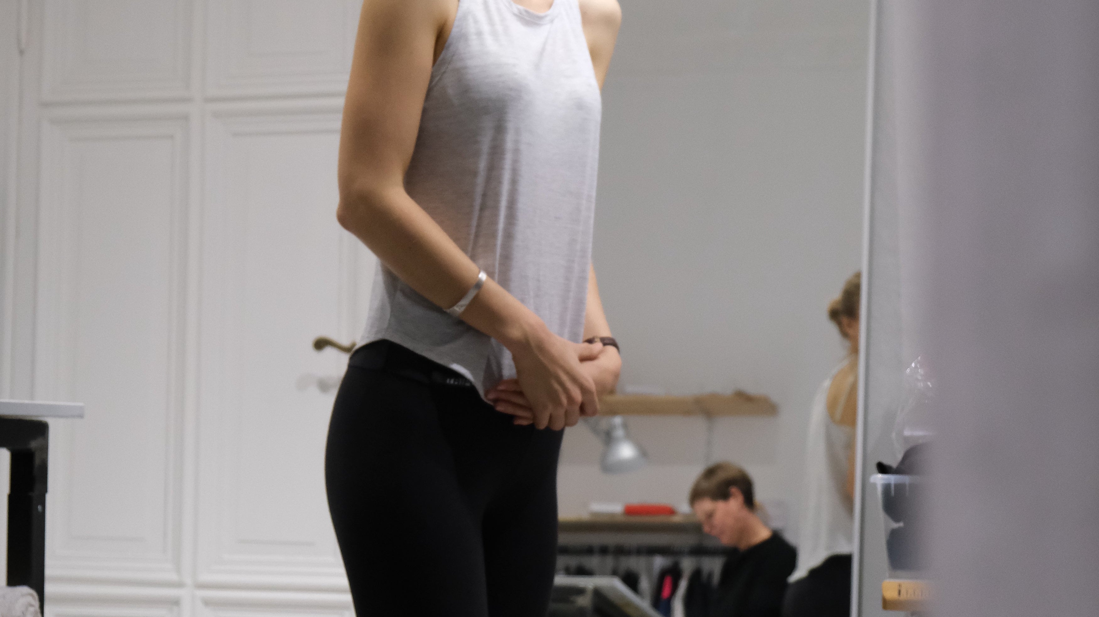 Early Tripulse fitting session: woman checking legging fit in a studio mirror.