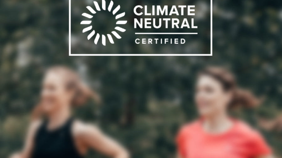 Two runners in a forest with the Climate Neutral Certified label overlay.