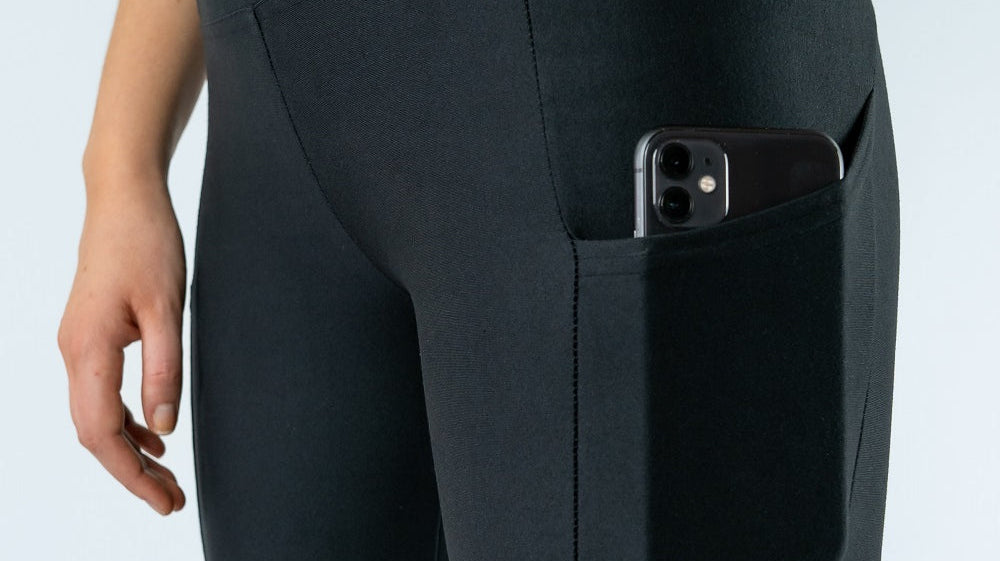 Close-up of black Tripulse leggings with a phone in the side pocket.