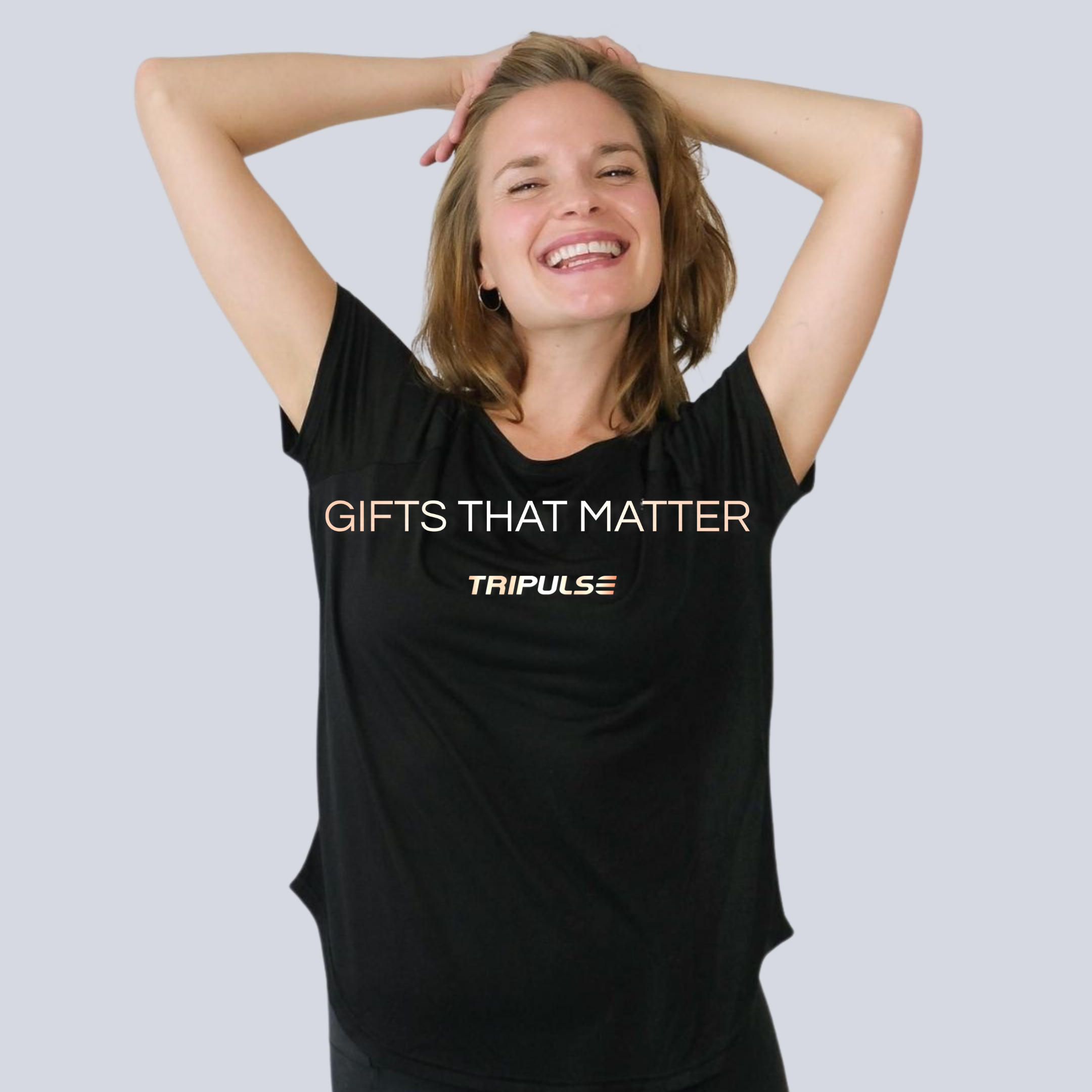 Laughing woman in a black Tripulse T-shirt printed with Gifts That Matter.