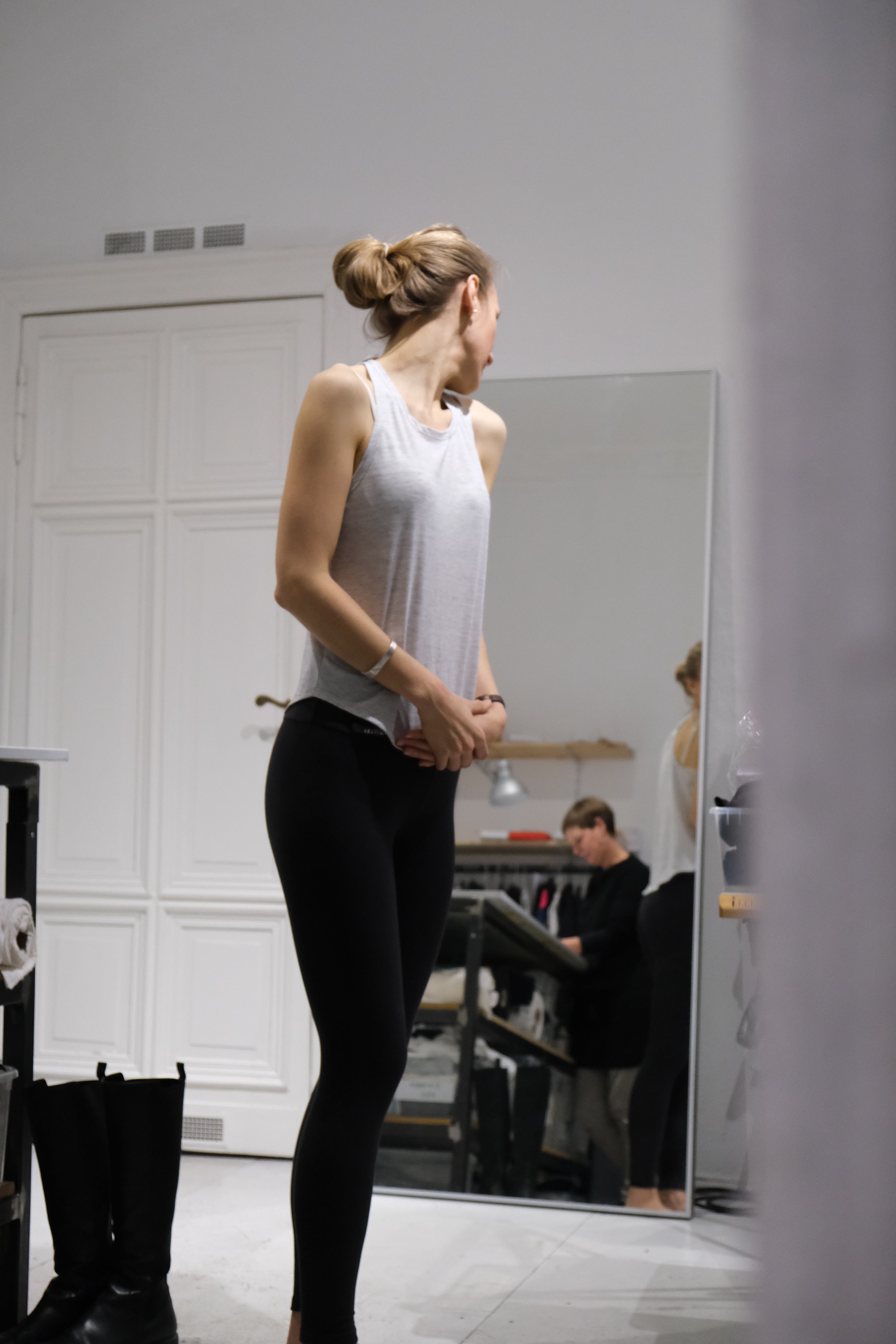 Early Tripulse fitting session: woman checking legging fit in a studio mirror.