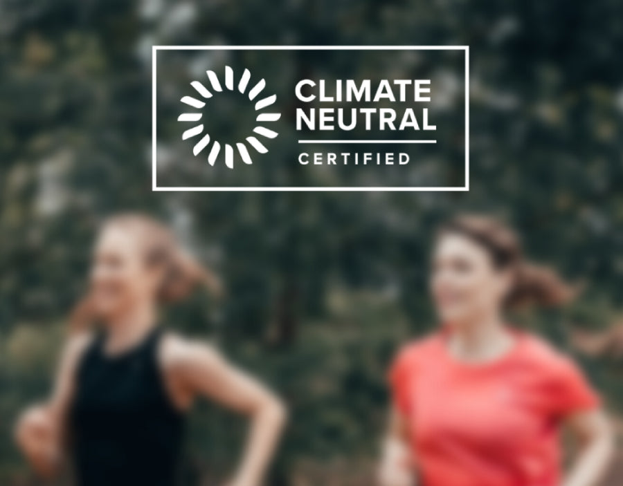 Two runners in a forest with the Climate Neutral Certified label overlay.
